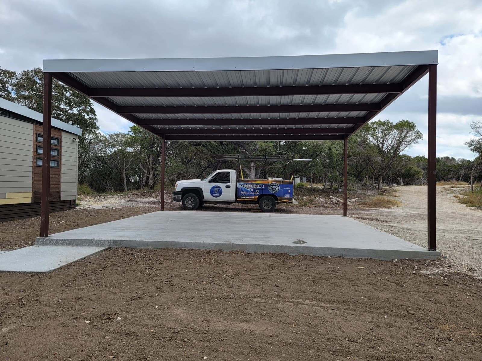 Welded metal carport over a pickup truck on a residential property near Fort Cavazos, Texas