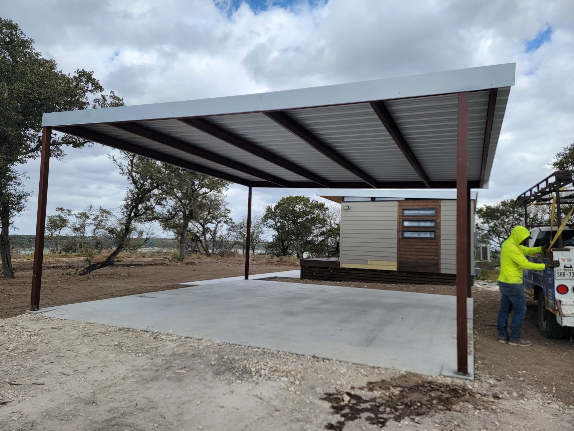 Rural carport with fresh concrete pad poured same contract