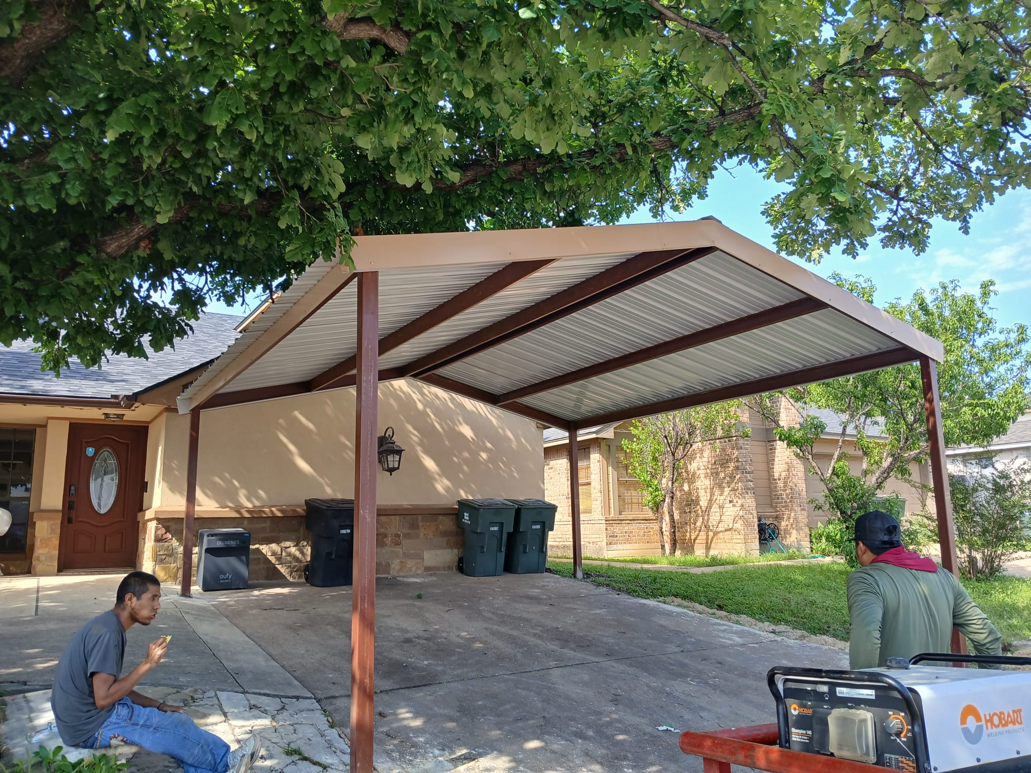 Completed residential carport with welded red iron frame