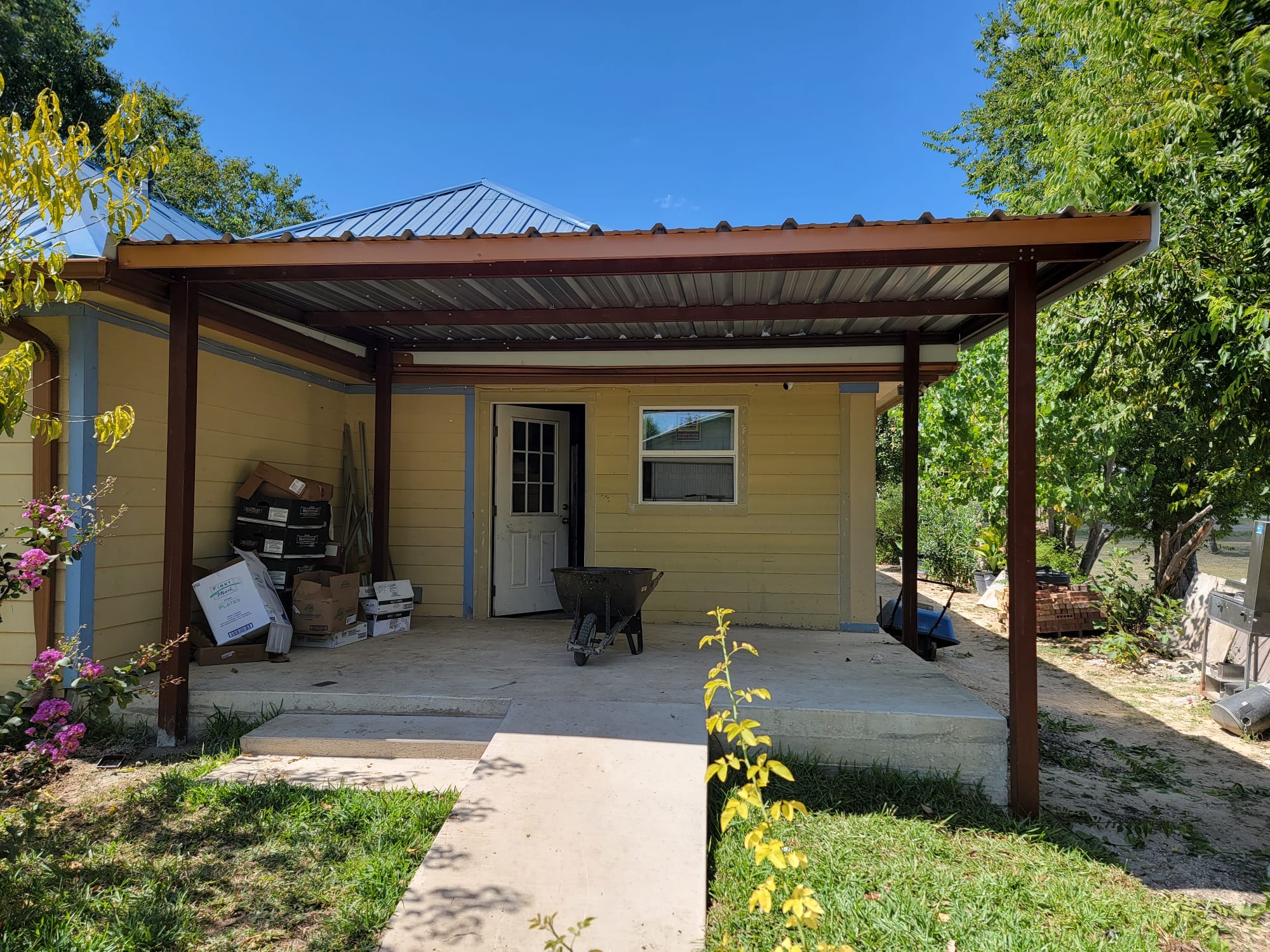 Metal lean-to porch cover attached to home
